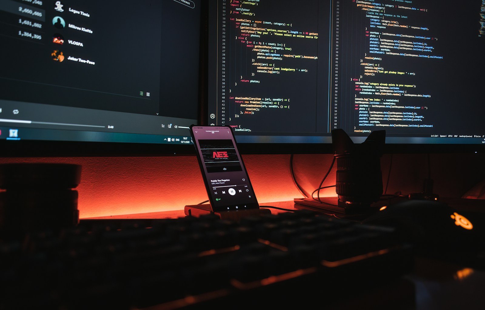 Code on two monitors above a backlit computer desk.