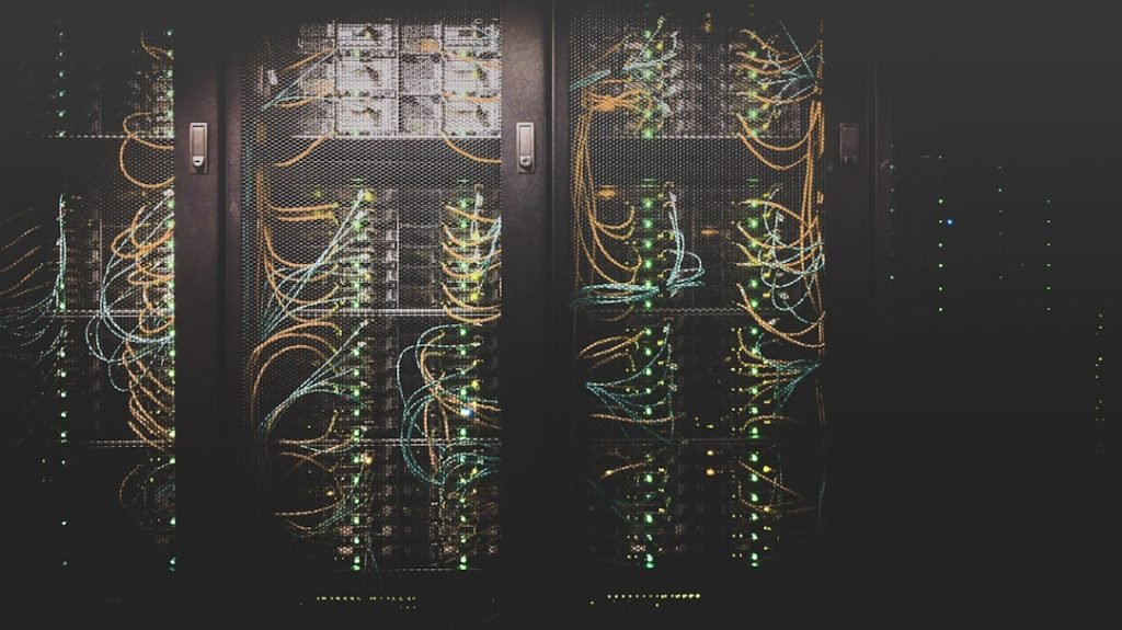 Rows of server racks and network cables in a data centre; representative photograph.
