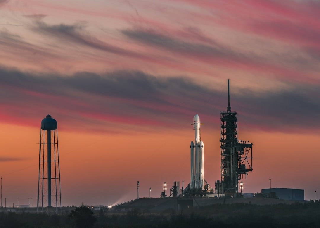Falcon Heavy standing on its launch pad at sunset.
