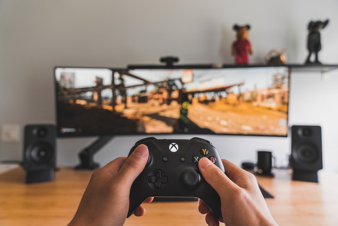 Person holding a black game controller, shown as a stock photograph.