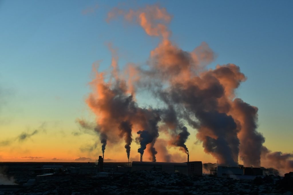 Steam rising from a geothermal power site in Iceland at sunset