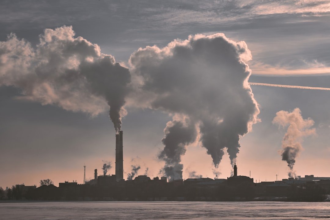 Industrial chimneys with plumes above a winter landscape