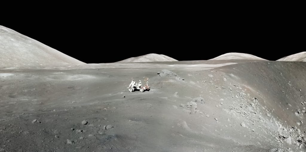 Lunar rover beside a crater on the Moon