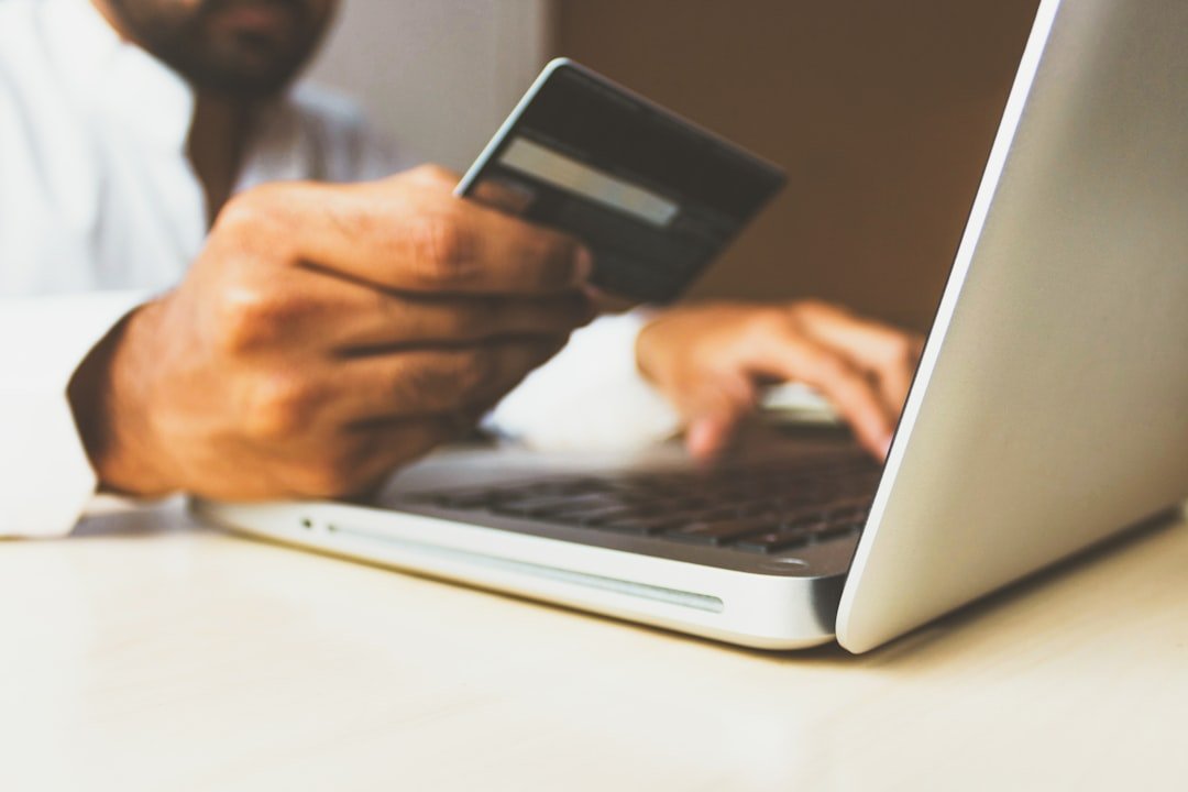 Person holding a payment card while shopping on a laptop