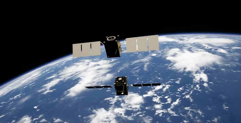 Illustration of two satellites with solar arrays above Earth