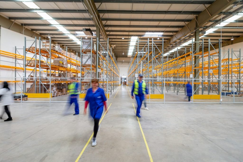 Workers and warehouse shelving in an industrial logistics building