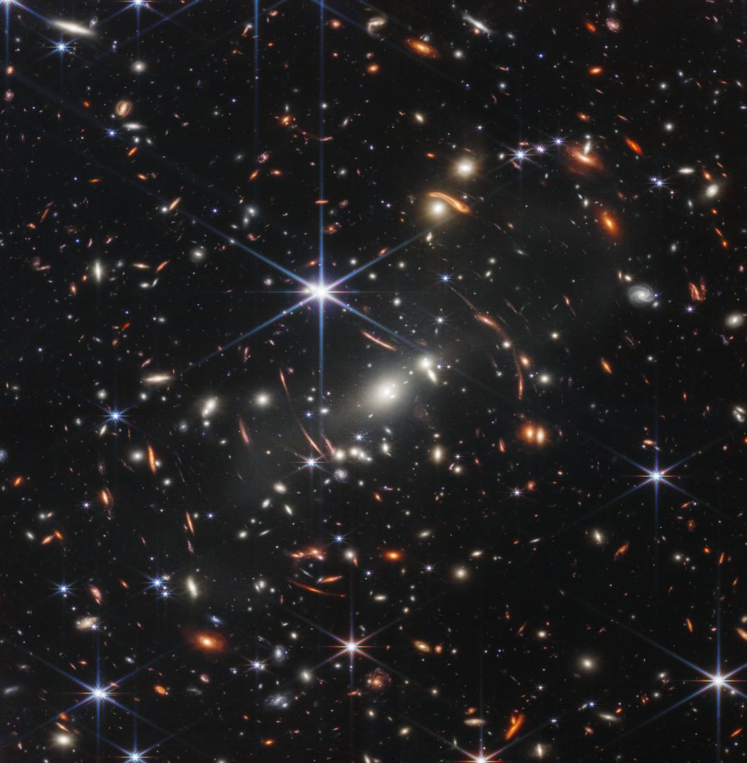 Webb’s First Deep Field shows numerous distant galaxies and bright foreground stars.