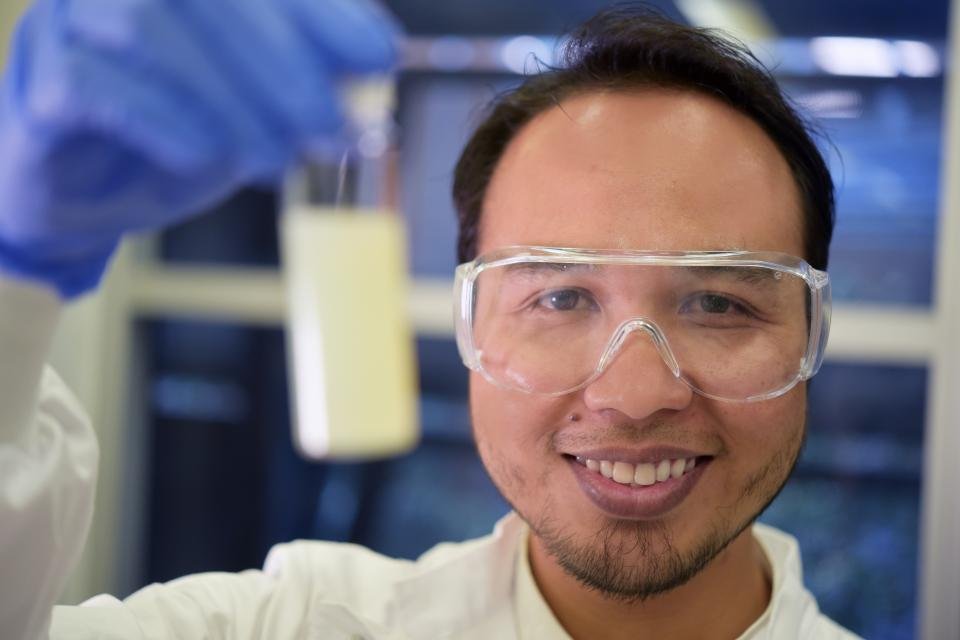Dr Asep Nugraha showing a coating sample in the laboratory