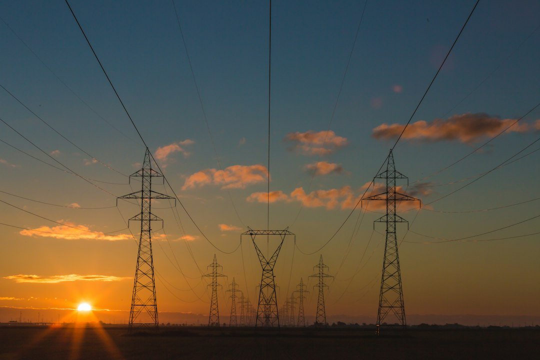 High-voltage electricity transmission towers at sunset