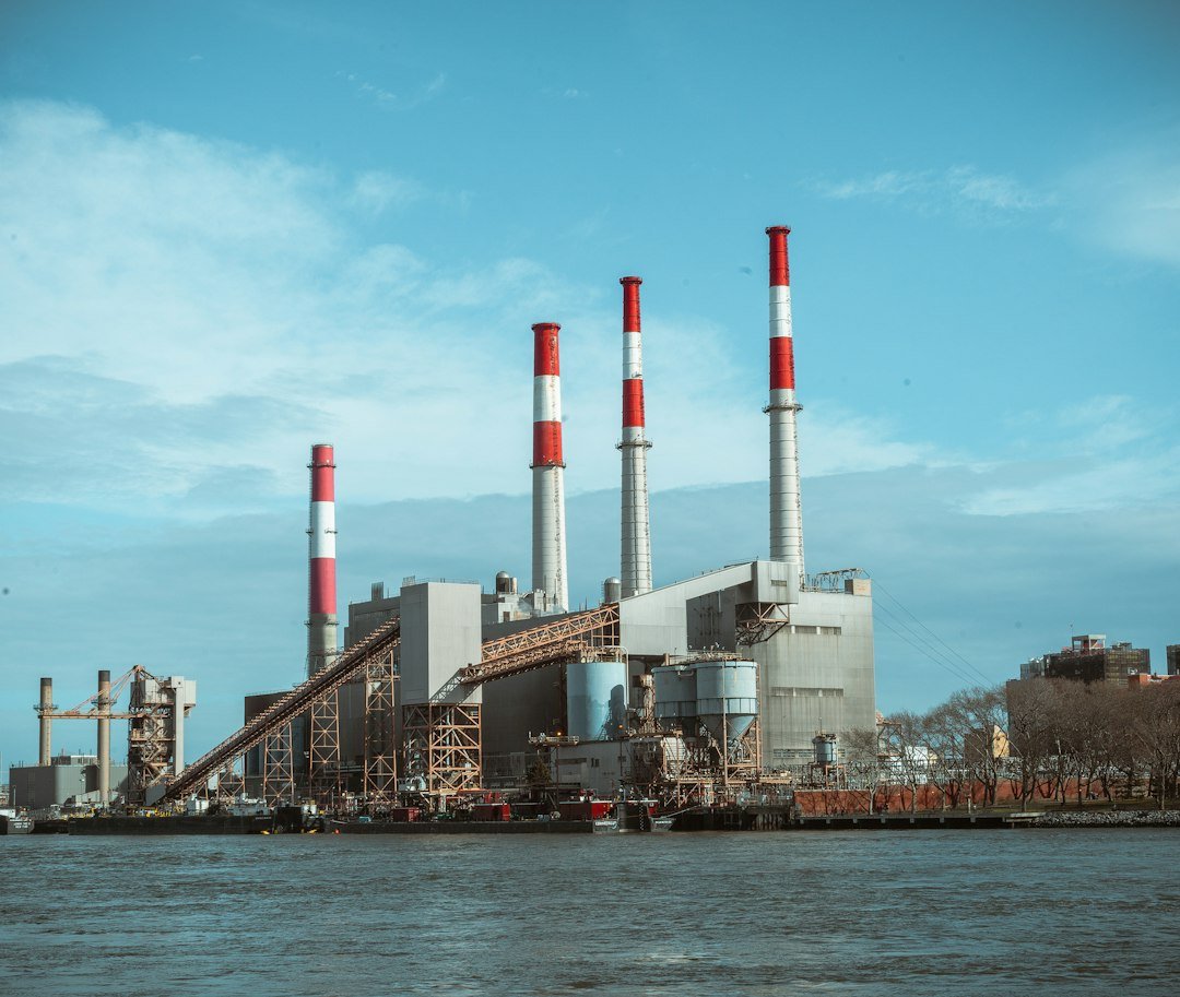 An industrial power station beside water with tall chimneys