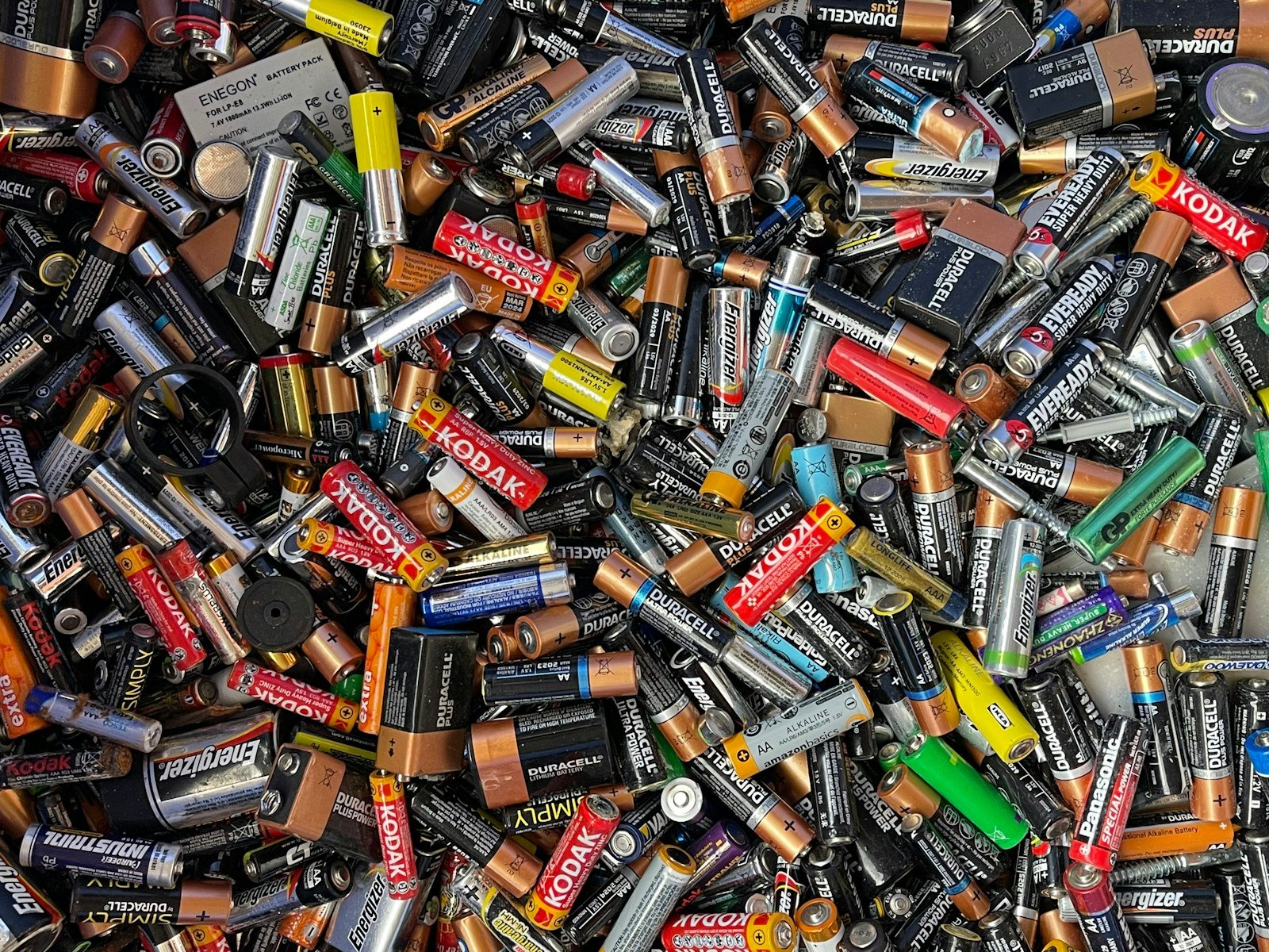 A pile of assorted used consumer batteries in different sizes