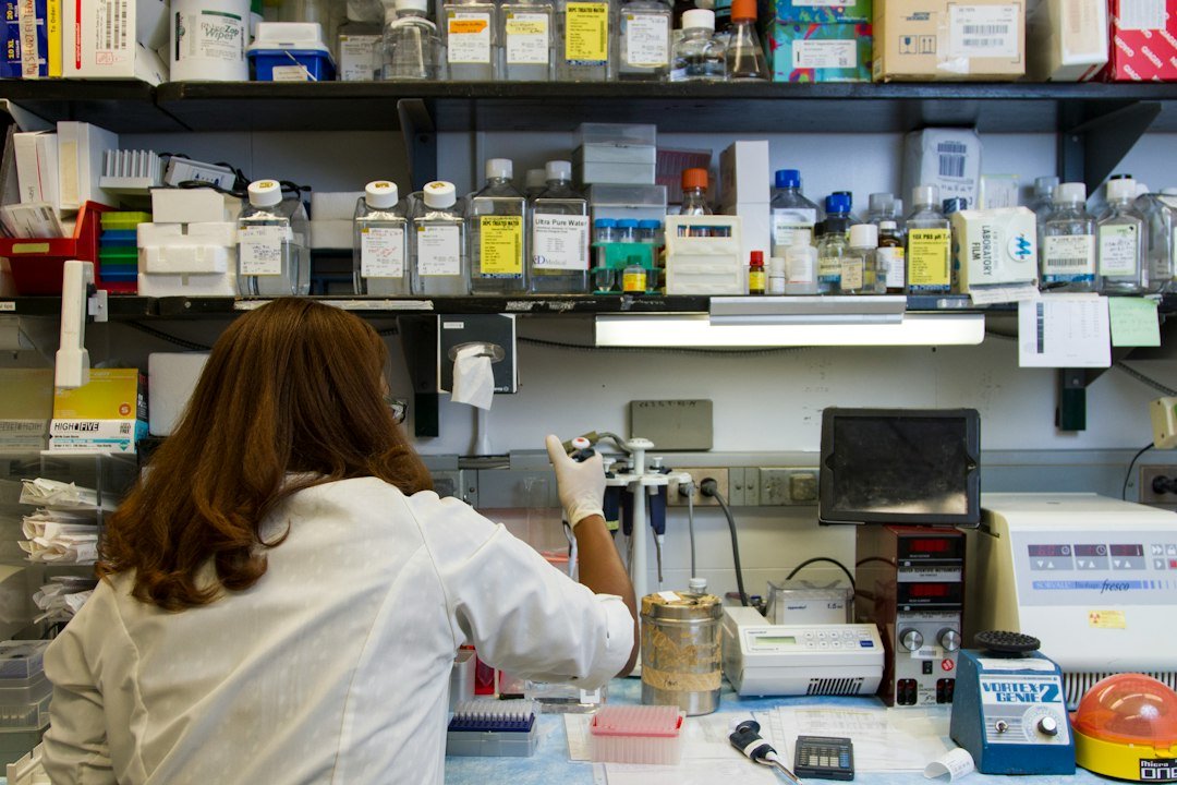 Researcher pipetting a laboratory sample into a tube