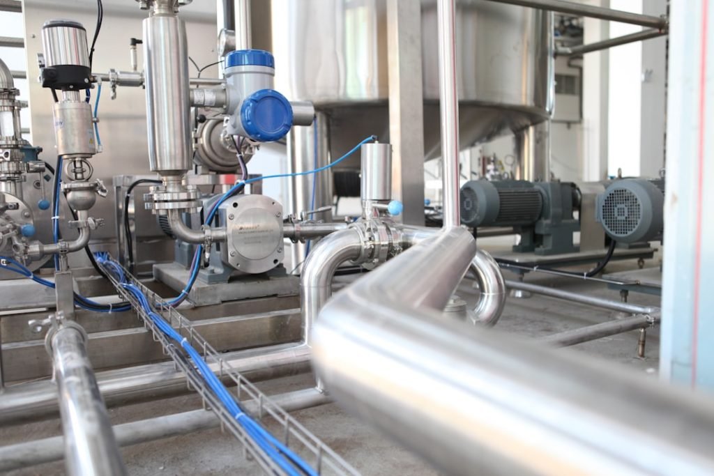 Industrial pumps and metal pipework inside a factory