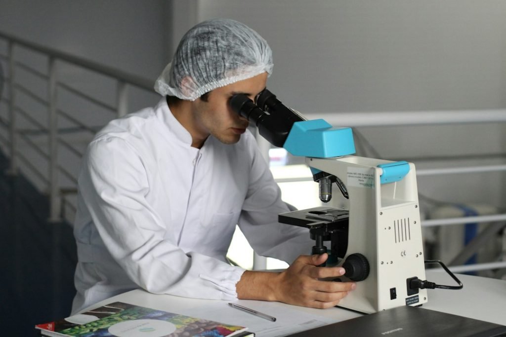 Laboratory worker examining a sample through a microscope