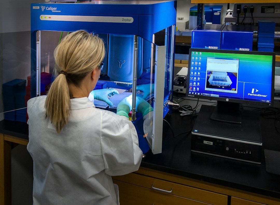 Scientist operating an automated molecular biology workstation